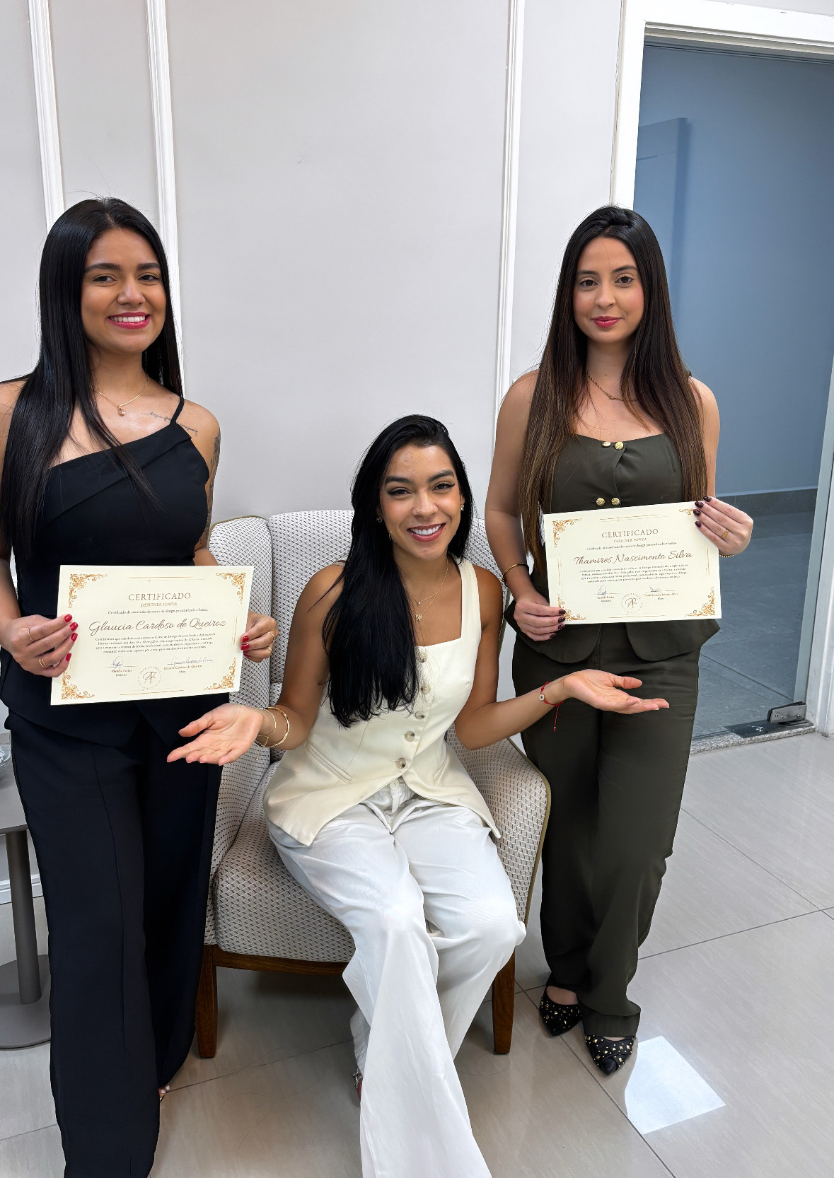 Alunas da formação sorrindo no ateliê com os certificados em mãos